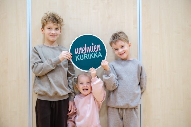 Lapsia käsissään unelmien kurikka kyltti